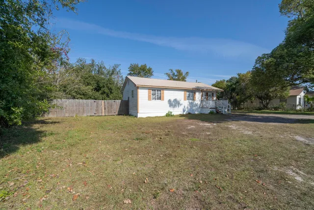 a view of house with backyard and tree