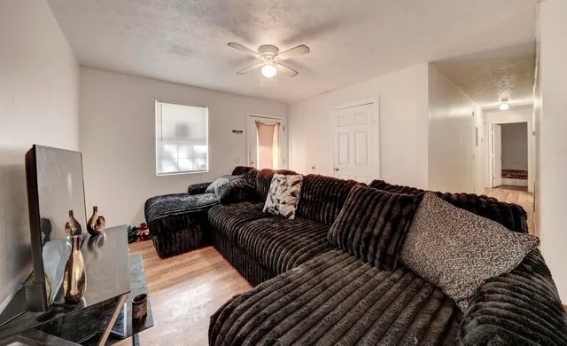 a living room with furniture a ceiling fan and a window