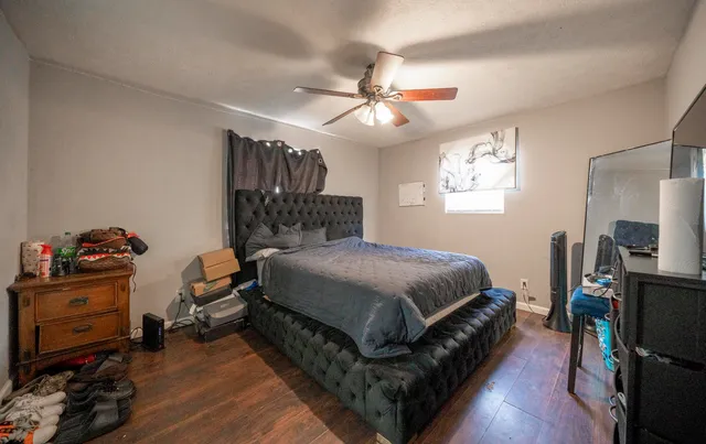 a spacious bedroom with a bed and a tv on the dresser