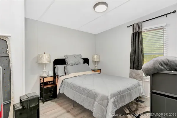 a bedroom with a bed and wooden floor