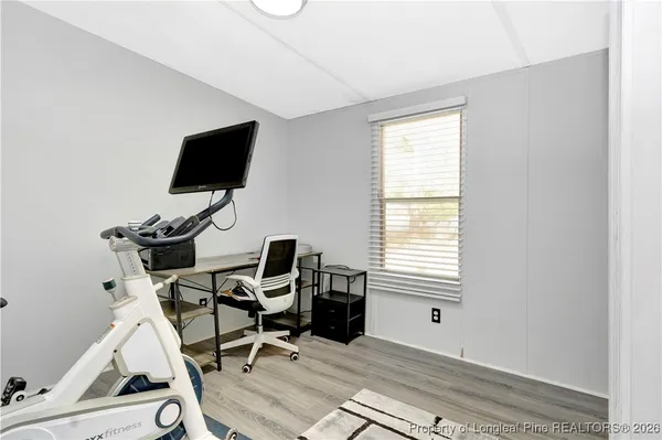 a view of a workspace with wooden floor and a window