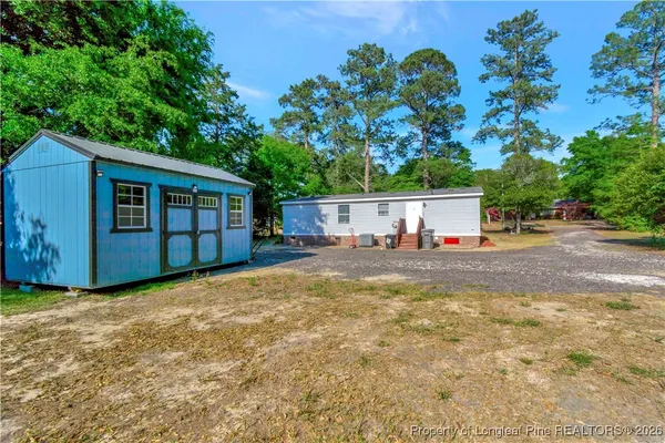 a view of a house with backyard and sitting area