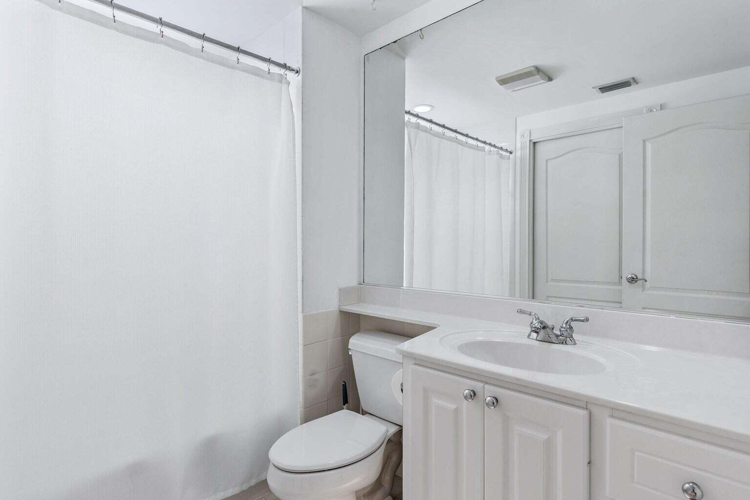 4030 Parkside Drive Jupiter, FL 33458 - Photo 13 of 26 a bathroom with a sink a toilet and a mirror