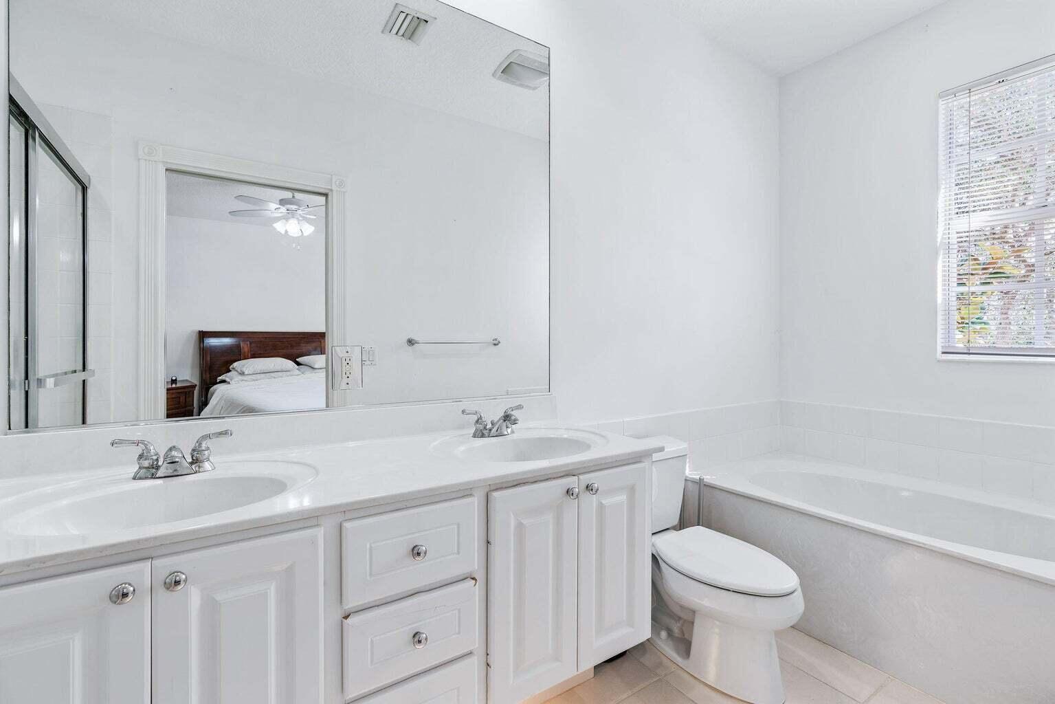 4030 Parkside Drive Jupiter, FL 33458 - Photo 15 of 26 a bathroom with a toilet a sink a tub and mirror