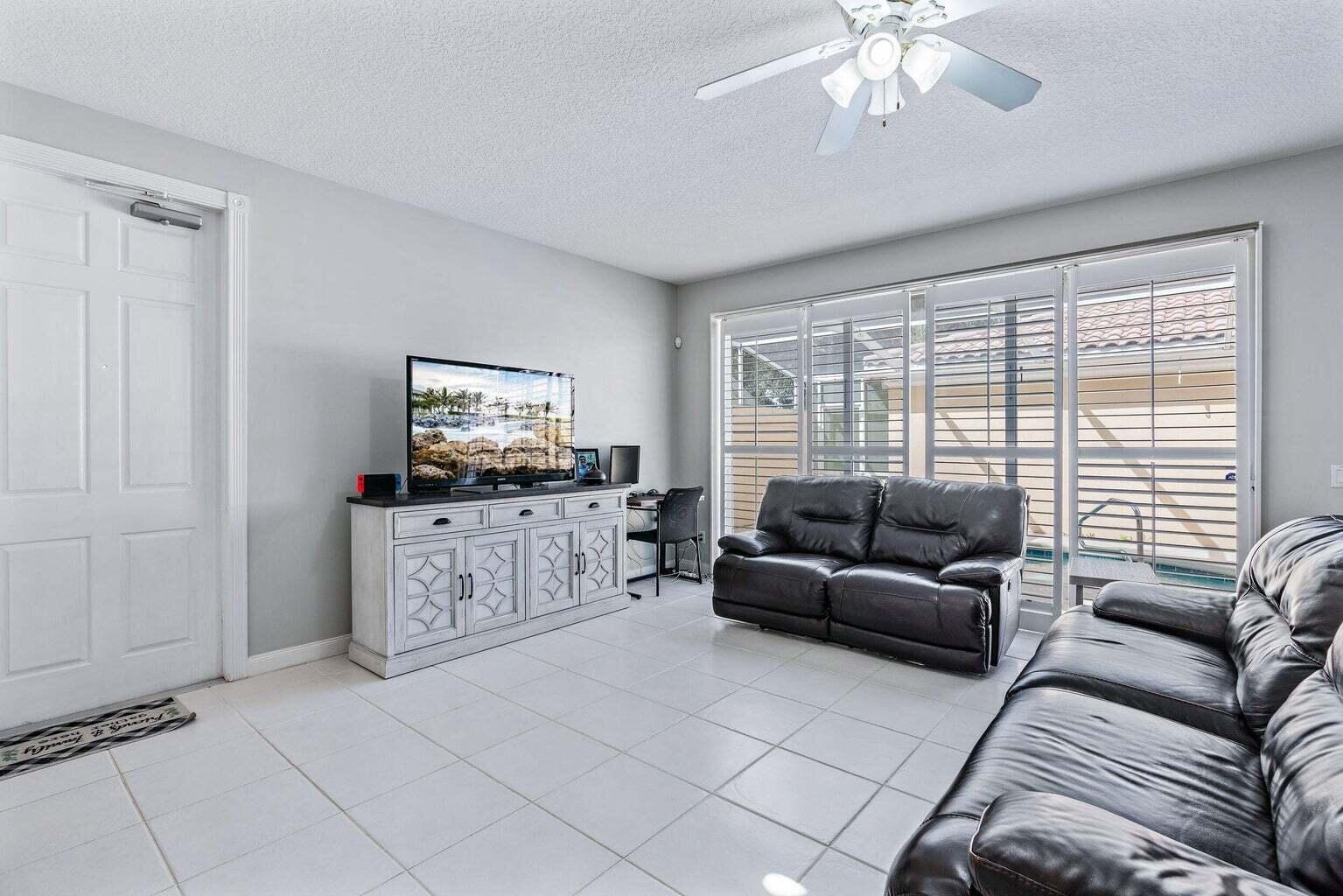 4030 Parkside Drive Jupiter, FL 33458 - Photo 9 of 26 a living room with furniture and a flat screen tv