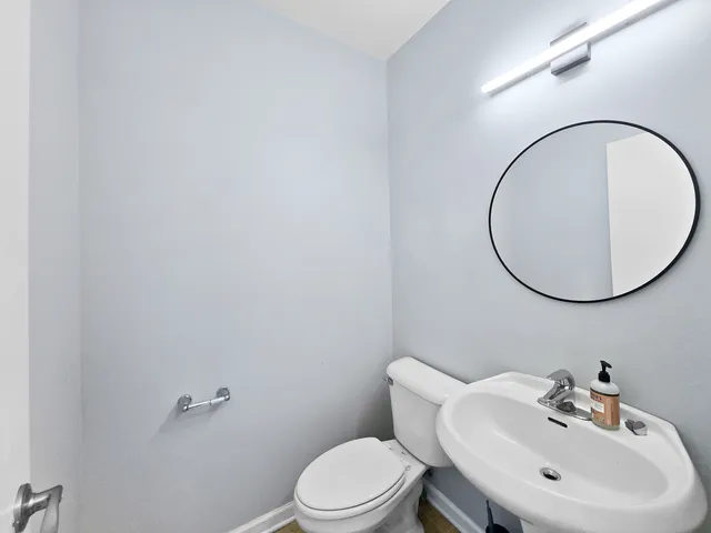 a bathroom with a toilet a sink and mirror