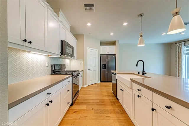 a large kitchen with stainless steel appliances granite countertop a sink and a stove