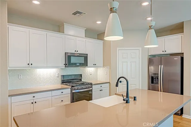 a kitchen with stainless steel appliances granite countertop a sink a stove and a refrigerator