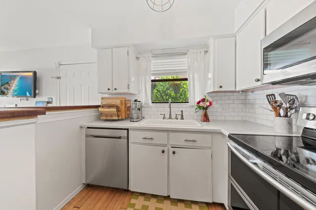 a kitchen with white cabinets and appliances