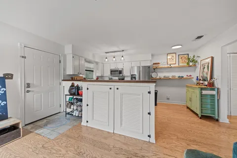 a kitchen with kitchen island a sink cabinets and wooden floor