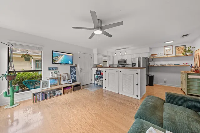 a living room with stainless steel appliances kitchen island granite countertop furniture and a flat screen tv