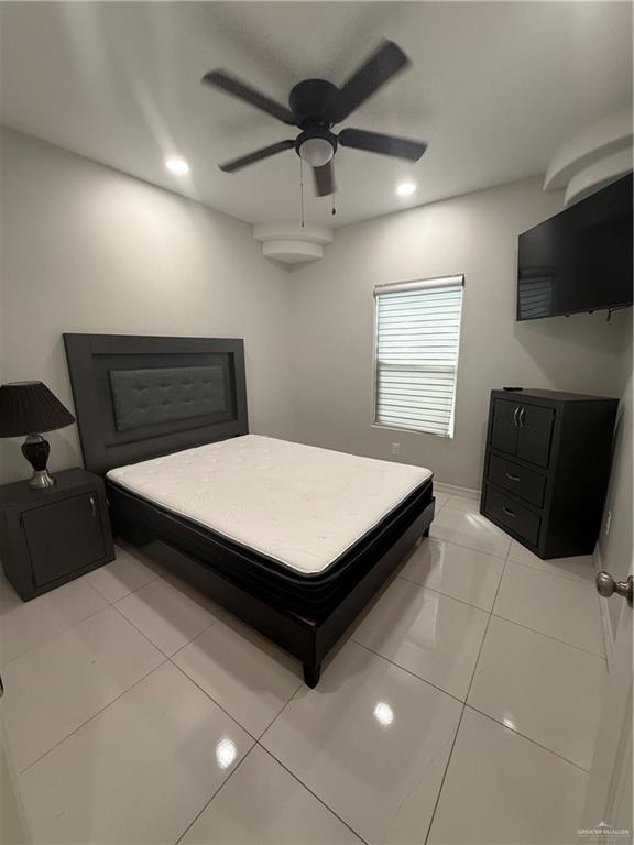 204 West Rutherford Avenue, Unit 4 Edinburg, TX 78541 - Photo 7 of 12 a living room with a bed furniture and a flat screen tv