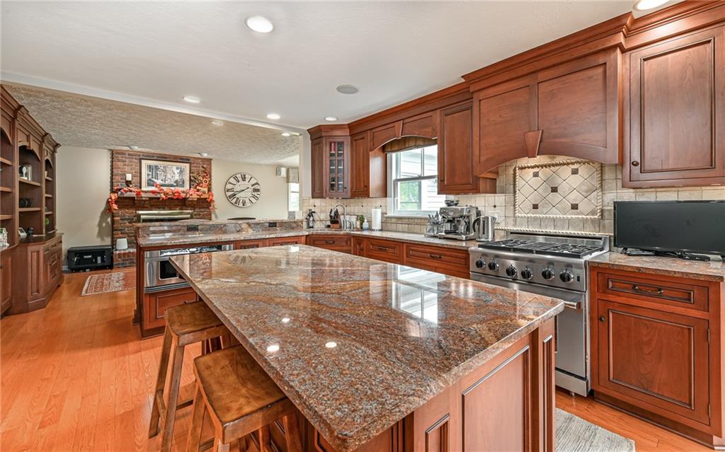 123 Weybridge Road Gibsonia, PA 15044 - Photo 6 of 25 a kitchen with stainless steel appliances granite countertop a sink a counter space and wooden floor