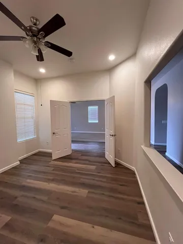 an empty room with windows and fan