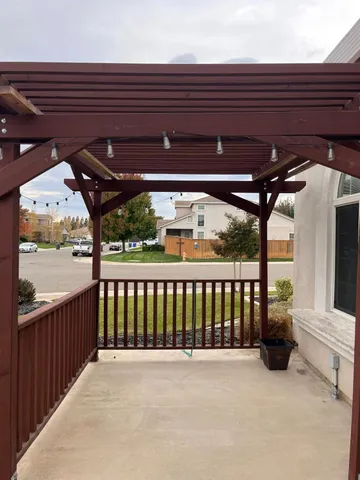 an empty room with wooden floor chandelier fan and windows
