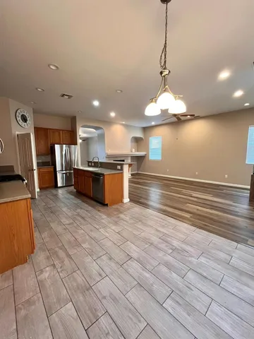 a view of kitchen with stainless steel appliances kitchen island sink refrigerator and microwave