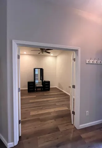 an empty room with windows and fan