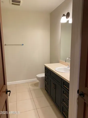 a bathroom with a granite countertop sink a toilet and a mirror