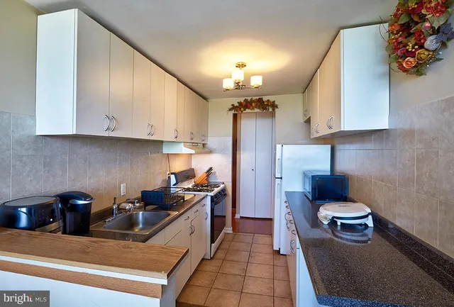 a kitchen with sink refrigerator and stove