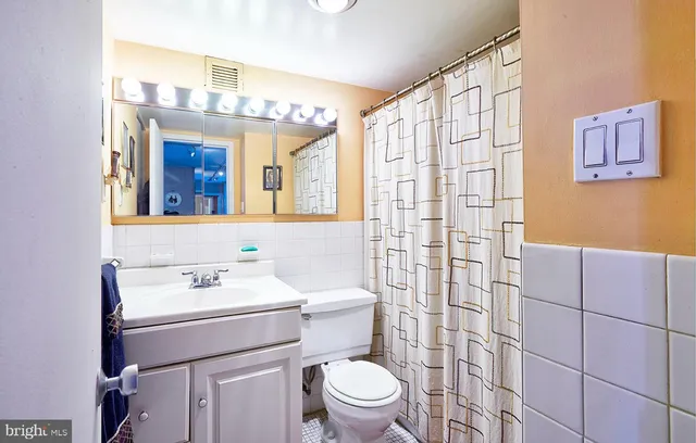 a bathroom with a sink a toilet and shower curtain