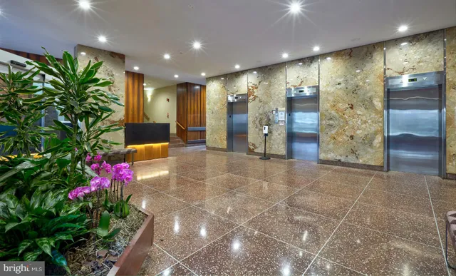 a lobby with furniture and potted plants