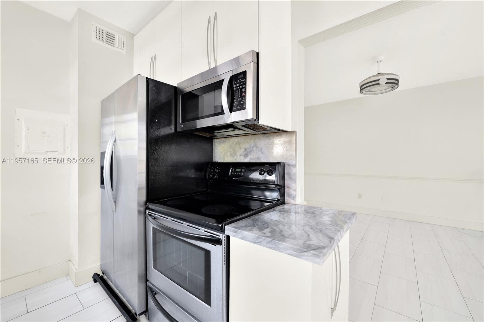 610 8th Street, Unit 102R Miami Beach, FL 33139 - Photo 13 of 22 a kitchen with a stove and a microwave