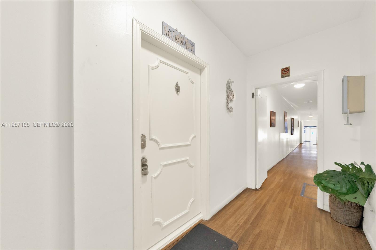 610 8th Street, Unit 102R Miami Beach, FL 33139 - Photo 4 of 22 a view of a hallway with wooden floor and a bathroom