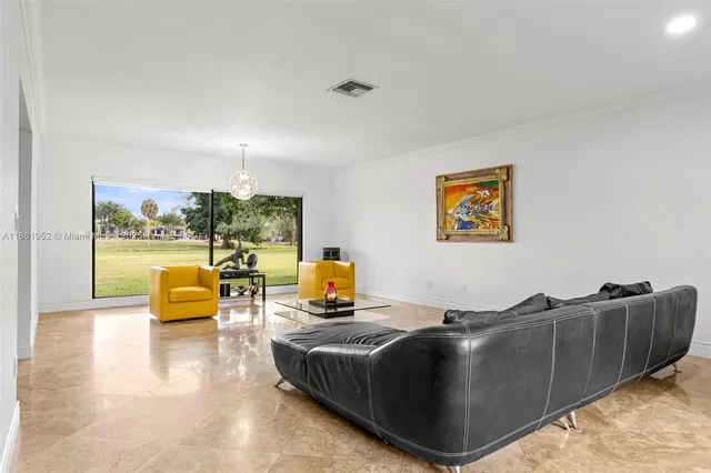 a kitchen with stainless steel appliances granite countertop a stove top oven a sink a dining table and chairs with wooden floor