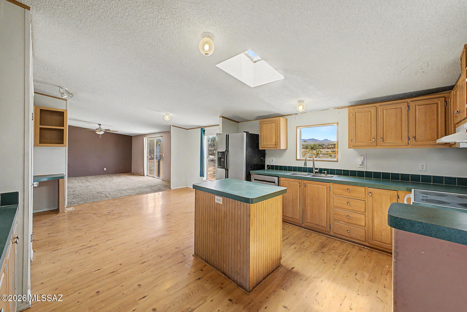 1911 West Thunder Road Vail, AZ 85641 - Photo 6 of 38 a kitchen with stainless steel appliances granite countertop a stove top oven a sink dishwasher and a refrigerator with wooden floor