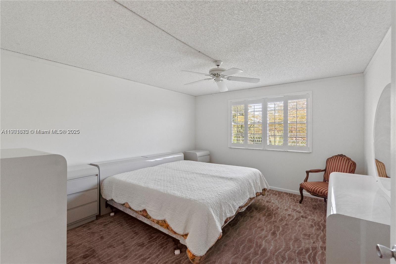 1603 Abaco Drive, Unit K4 Coconut Creek, FL 33066 - Photo 23 of 36 a bedroom with a bed chair and window