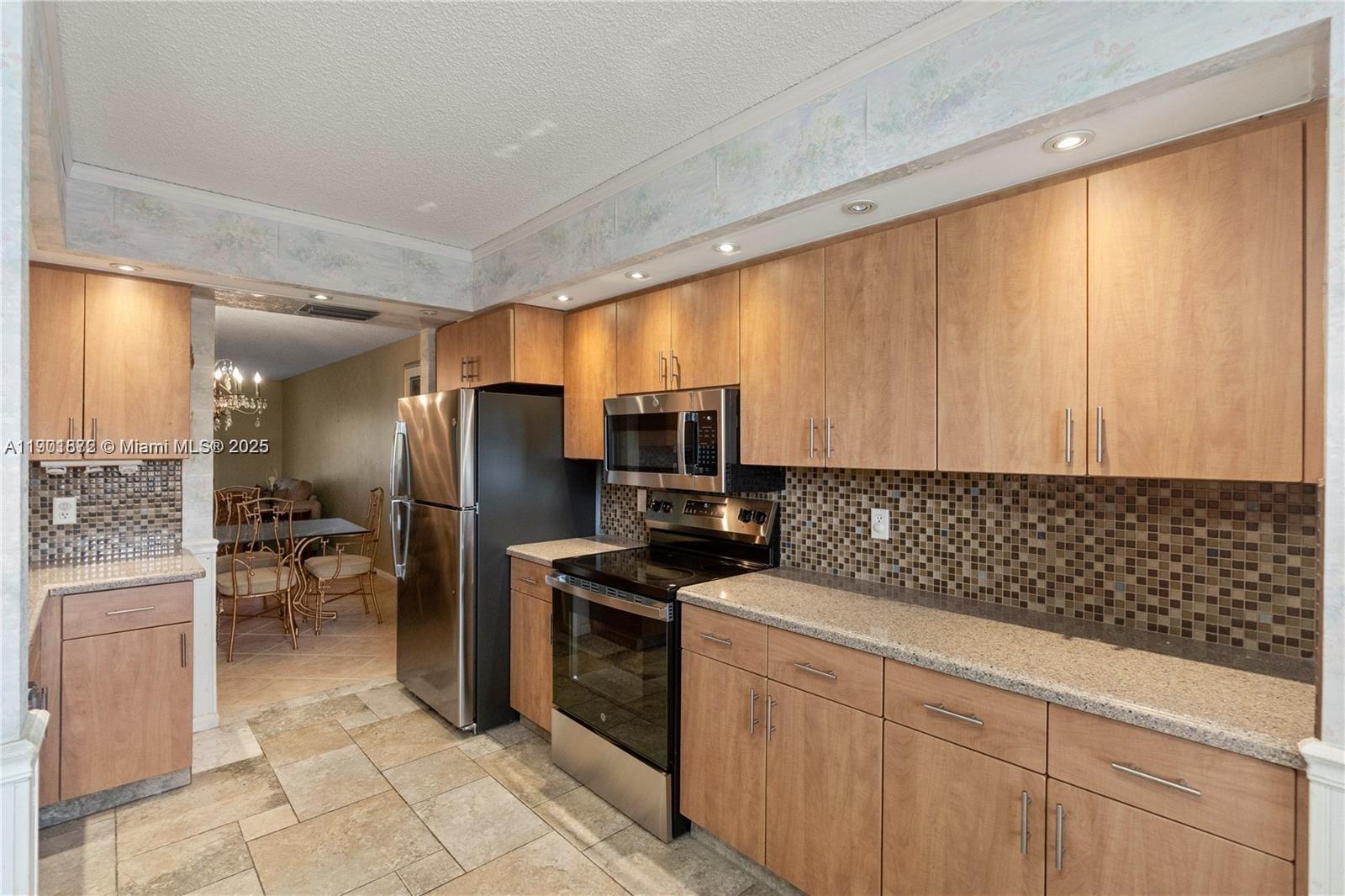 1603 Abaco Drive, Unit K4 Coconut Creek, FL 33066 - Photo 7 of 36 a kitchen with a sink cabinets and stainless steel appliances