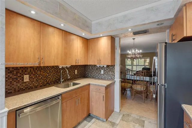 a kitchen with stainless steel appliances a refrigerator sink and cabinets