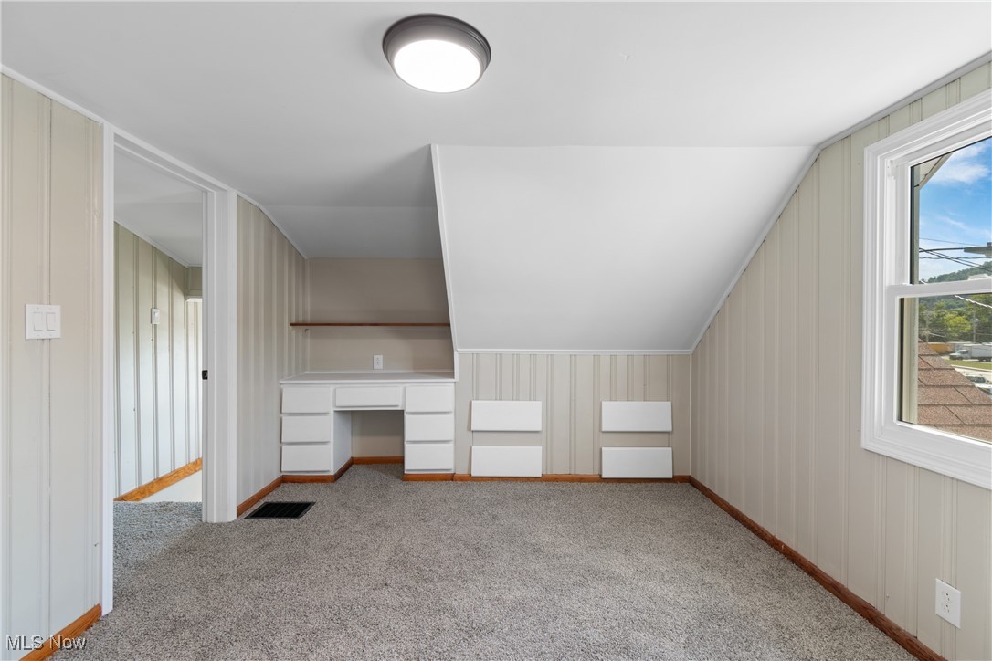 56321-56323 Riley Road Bridgeport, OH 43912 - Photo 16 of 40 Additional living space featuring light colored carpet, vaulted ceiling, and a healthy amount of sunlight