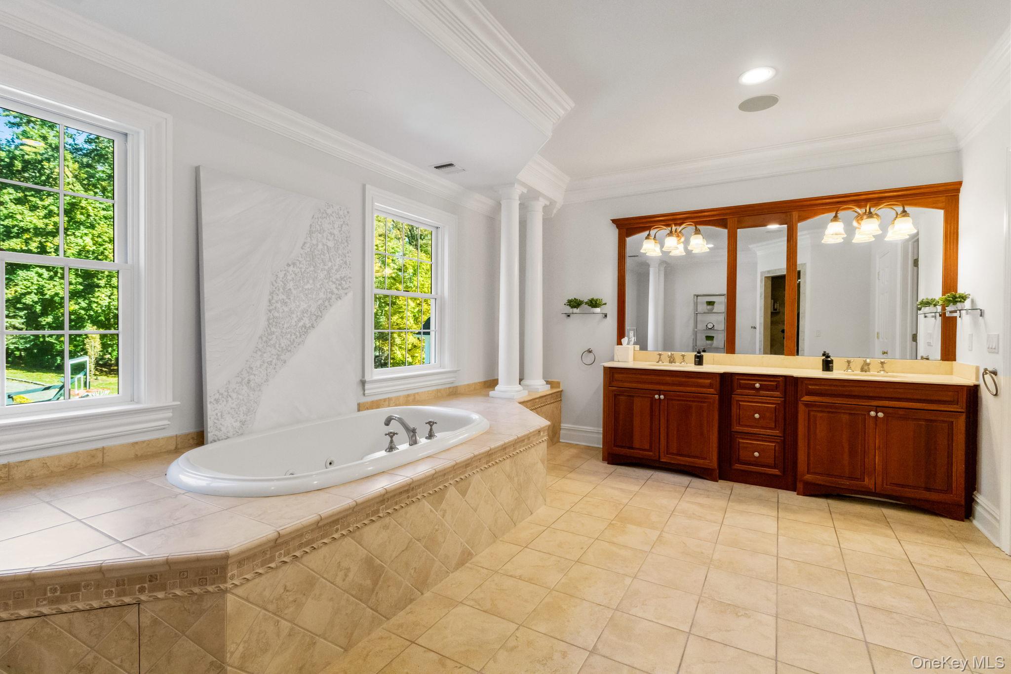 496 Long Ridge Road Bedford, NY 10576 - Photo 25 of 49 Full bathroom featuring double vanity, a tub with jets, ornamental molding, light tile patterned floors, and a chandelier