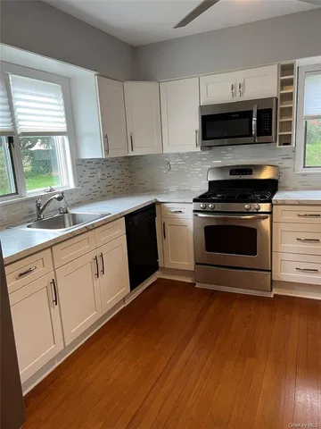 a kitchen with sink a microwave and cabinets