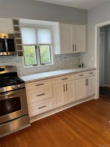 a kitchen with granite countertop white cabinets and white appliances
