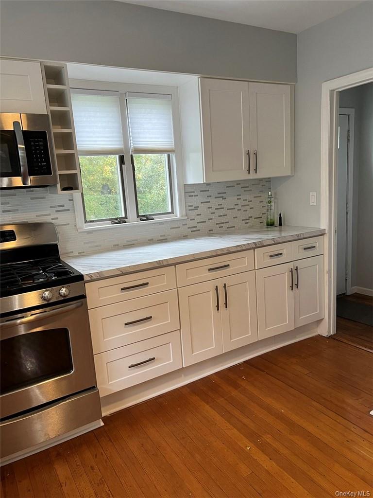 39 Wilmot Road, Unit 1 Scarsdale, NY 10583 - Photo 3 of 18 a kitchen with granite countertop white cabinets and white appliances
