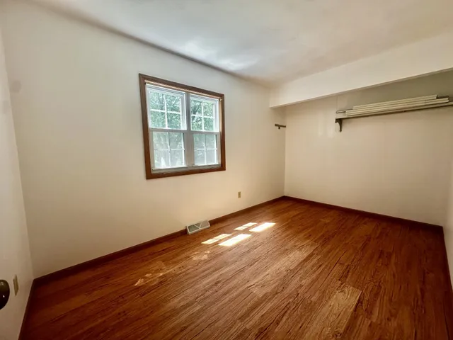a view of a room with wooden floor and window