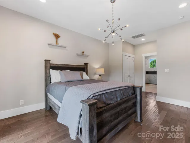 a bedroom with a bed and a chandelier