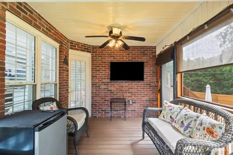 a living room with furniture a flat screen tv and a floor to ceiling window