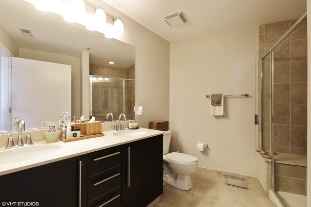 225 South Sangamon Street, Unit 512 Chicago, IL 60607 - Photo 7 of 11 a bathroom with a double vanity sink toilet and shower