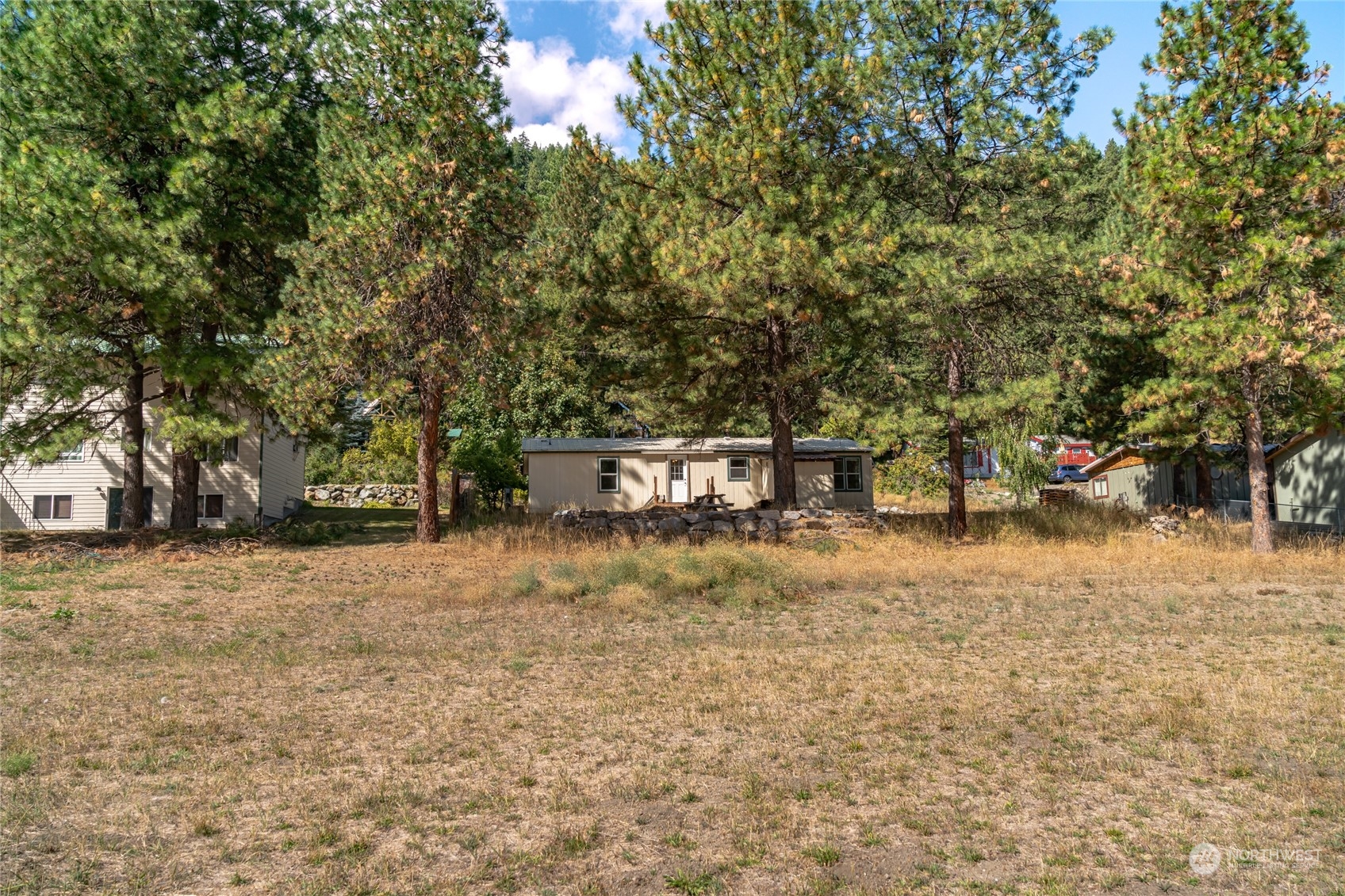 3509 Hansel Lane Peshastin, WA 98847 - Photo 29 of 33 a backyard of a house with large trees and outdoor seating