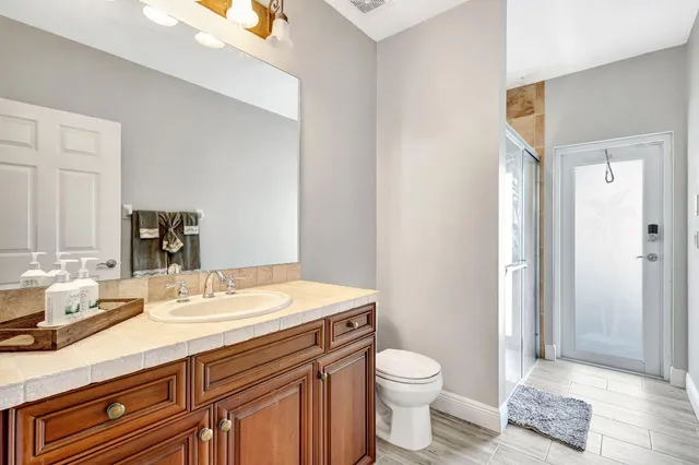 a bathroom with a sink a toilet and shower