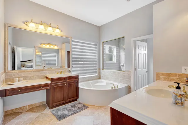 a bathroom with a granite countertop sink and a bathtub