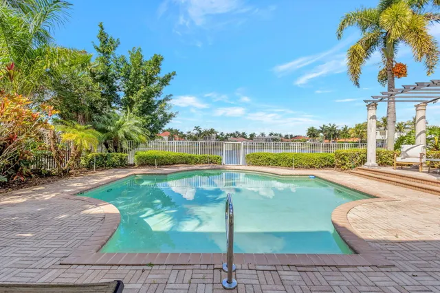 a view of a swimming pool with a lawn chairs under an umbrella