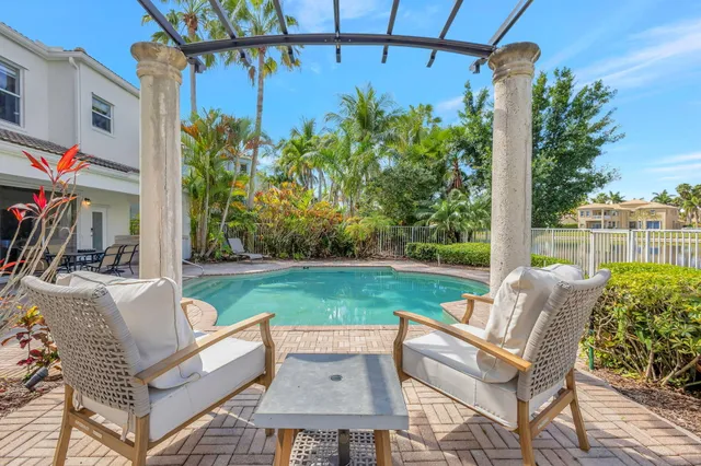 a view of a patio with couches chairs potted plants and palm tree