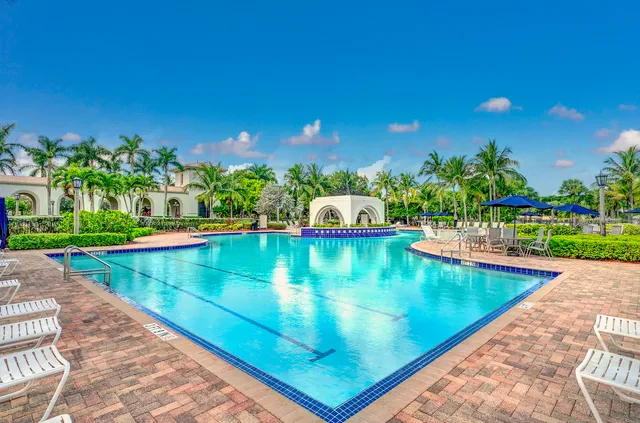 a view of a swimming pool with a yard and sitting area