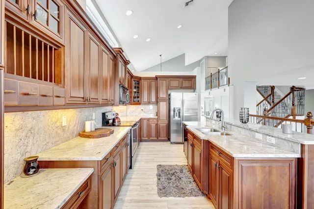 a kitchen with stainless steel appliances granite countertop a sink stove and cabinets