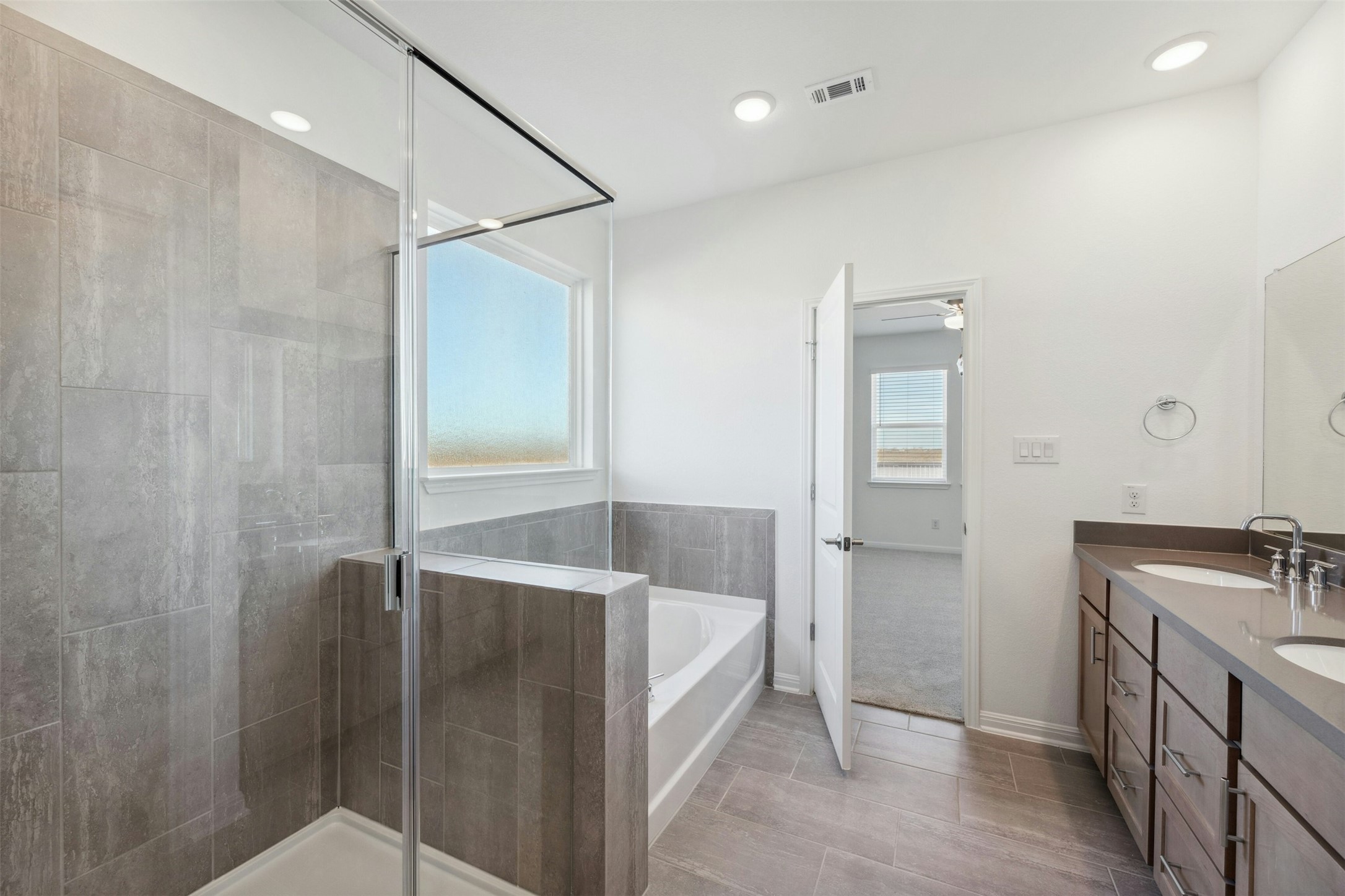 2001 Wynn Road Hutto, TX 78634 - Photo 18 of 39 A well-lit bathroom with dual sinks and a separate glass-enclosed shower.