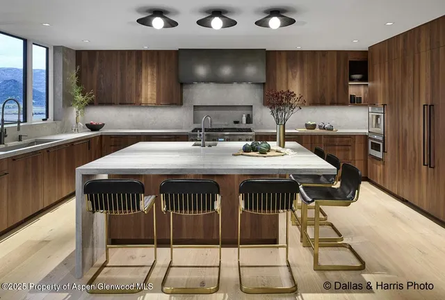 a kitchen with a sink a stove and chairs
